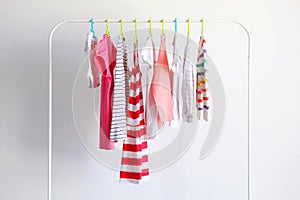 Children clothes on a rack on a light background.