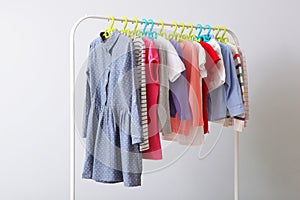 Children clothes on a rack on a light background.