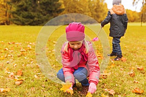 Children collecting leaves in autumn park