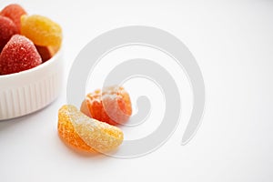 Children colorful gummy vitamins on white background. Multivitamin soft jelly candies in form of different kind of fruit.