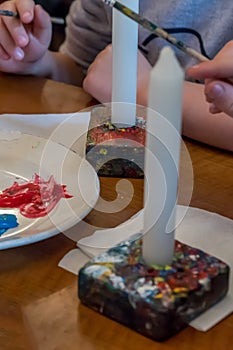 Children colorize candles with acrylic paints