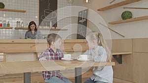 Children communicating at meeting in a cafeteria