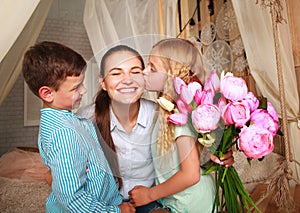 Children congratulate mother give her bouquet of flowers