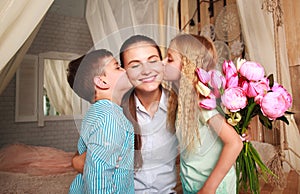 Children congratulate mother give her bouquet of flowers