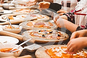 Children cook pizza. Master class from the chef in a restaurant, Close-up of children`s hands roll out the dough