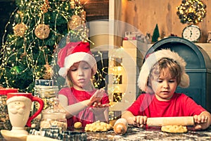 Children cooking for christmas. Christmas cookery. Funny kids are preparing the dough playing with flour in the kitchen.