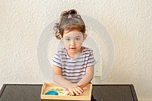 Children creativity. Kid sculpts from clay. Cute little girl moulds from plasticine on table.