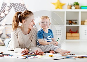 Children creativity. mother and baby son drawing together