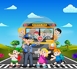 The children cross the road while the police stop the school bus and the children waving