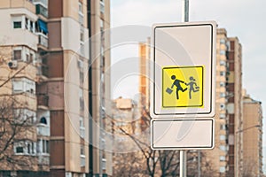 Children crossing in proximity of school traffic sign a warning and advising road users to drive extra slowly photo