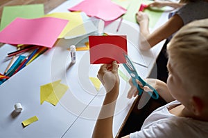 Children cut colored paper, kids in art school