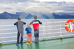 Children, cute boys, looking at the mountains from a ferry in Nortern Norway on his way