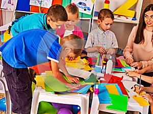 Children cutting paper in class. Development social lerning in school.