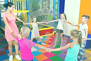 Children dancing with teacher to music in class at school