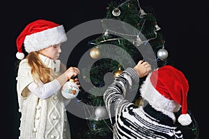 Children decorate the Christmas tree in the room.