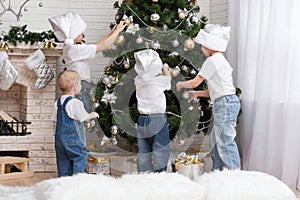 Children decorate a Christmas tree toys