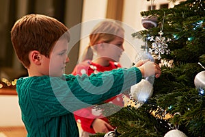 Children Decorating Christmas Tree At Home