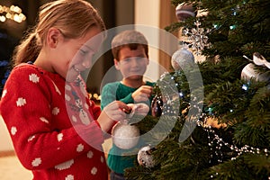 Children Decorating Christmas Tree At Home