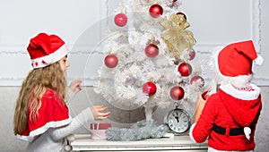 Children decorating christmas tree together. Siblings busy decorating. Boy and girl decorating tree. Cherished holiday