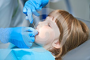 Children dentistry. Liitle girl an dentist examination, teeth cleaning and treatment.