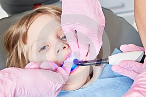 Children dentistry. Litle girl an dentist examination, teeth cleaning and treatment.