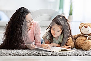 Children Development Concept. Loving Young Mom Reading Book To Her Little Daughter