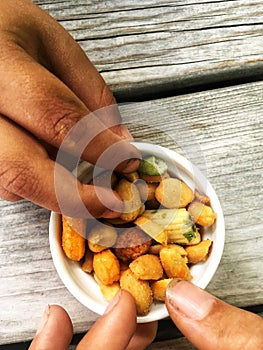 Children with dirty fingers grabbing a nut from a little bowl