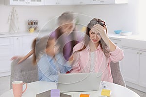 Children disturbing overwhelmed woman in kitchen. Working from home during quarantine