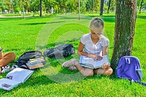 Children do homework in the park, a boy and a girl are preparing for school