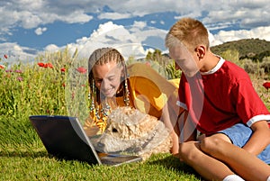 Children with dog at computer