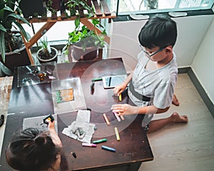 Children doing arts and crafts at home. Sibllings spend time together at home