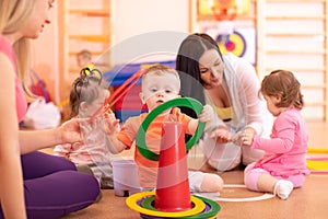 Children doing physical activities with nursery teacher in preschool