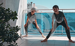 Children doing sport exercises on balcony. Sport, healhty lifestyle, active leisure at home