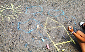 Children draw the Ukrainian flag house on the pavement. Selective focus.