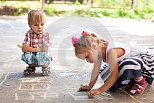 Children drawing on asphalt family house