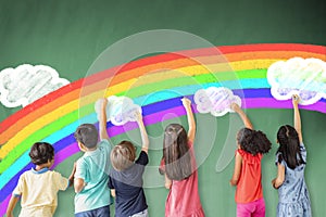 Children drawing rainbow and cloud on the chalkboard photo
