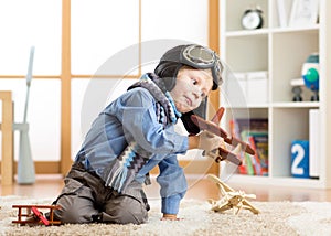 Children dreams and imagination concept. Adorable little boy playing with wooden airplane