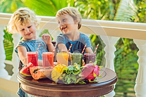 Children drink colorful healthy smoothies.. Watermelon, papaya, mango, spinach and dragon fruit. Smoothies, juices