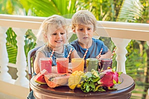 Children drink colorful healthy smoothies.. Watermelon, papaya, mango, spinach and dragon fruit. Smoothies, juices