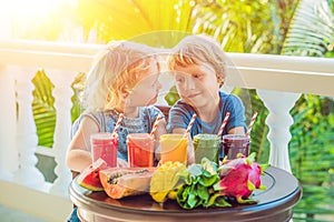 Children drink colorful healthy smoothies.. Watermelon, papaya, mango, spinach and dragon fruit. Smoothies, juices