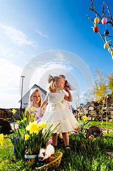 Children on Easter egg hunt with bunny