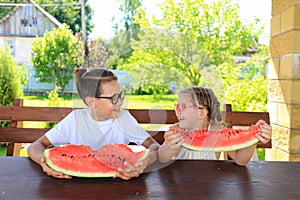 Children eat big watermelon in summer.