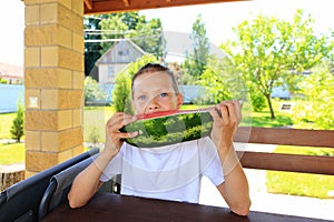 Children eat big watermelon in summer.