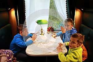 Children eating burgers in compartment of train carriage
