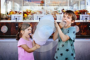 Children eating cotton candy at the carnival