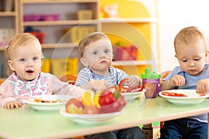 Children eating healthy food in nursery or kindergarten