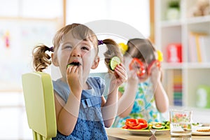 Children eating vegetables in kindergarten or at home