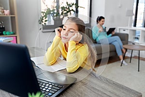 Student girl with laptop learning online at home