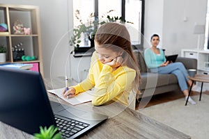 Student girl with laptop learning online at home