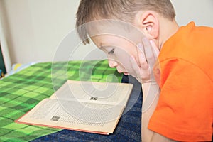 Children education, kid reading book lying on bed, serious child read with book, education, interesting fairy tale